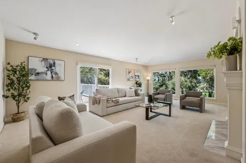 a living room with furniture a fireplace and a large window