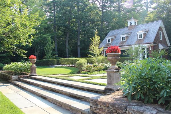 174 Highland Street Weston, MA 02493 - Photo 7 of 29 a front view of a house with a yard and potted plants
