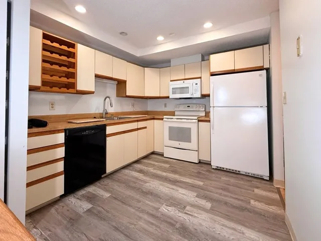 a kitchen with a refrigerator sink and cabinets