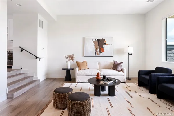 a living room with furniture and wooden floor