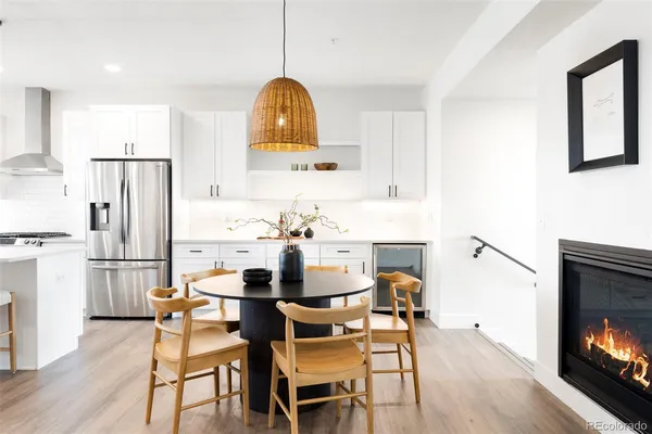 a kitchen with a stove a sink and a dining table with wooden floor