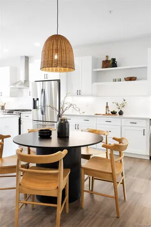a kitchen with stainless steel appliances granite countertop a stove a refrigerator a kitchen island a table and chairs