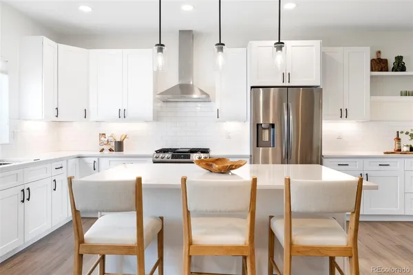 a kitchen with a sink a stove and white cabinets