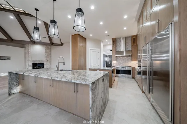 a large kitchen with stainless steel appliances kitchen island granite countertop a sink and cabinets