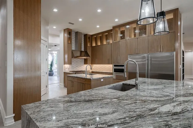 a kitchen with stainless steel appliances granite countertop a refrigerator and a sink