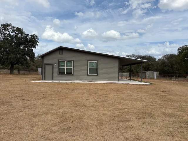 a backyard of a house with table and chairs