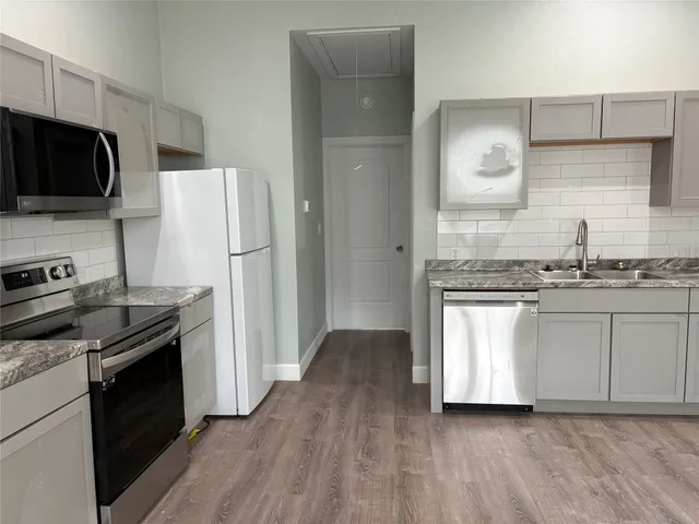 a kitchen with stainless steel appliances a refrigerator stove and microwave