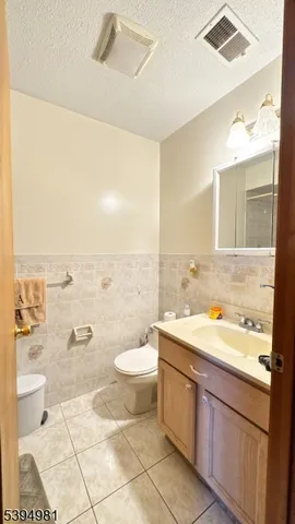 a bathroom with a granite countertop sink a toilet a mirror and bathtub