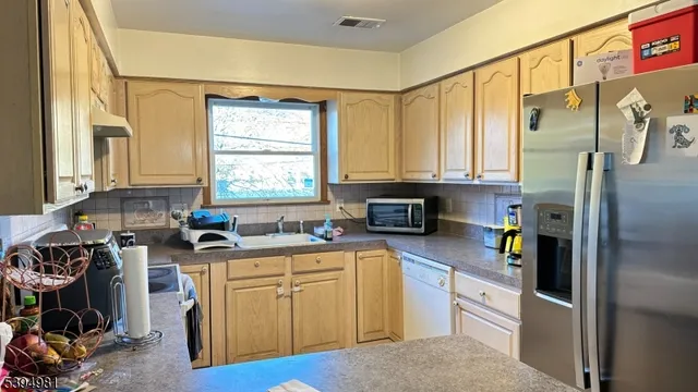 a kitchen with a refrigerator a stove a sink and a window
