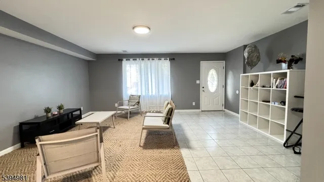 a living room with furniture a air conditioner vent and a window