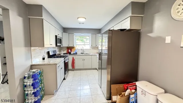 a kitchen with a sink a refrigerator a window and a counter top space