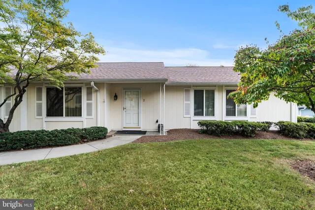 a front view of a house with a garden and plants