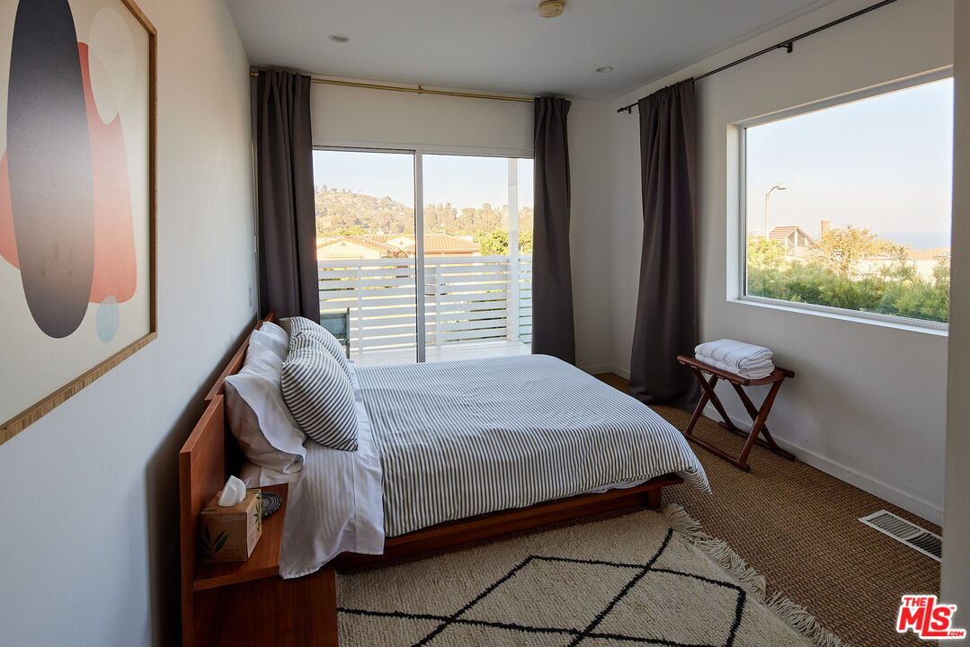 3817 Surfwood Road Malibu, CA 90265 - Photo 14 of 26 a bedroom with a bed and a large window