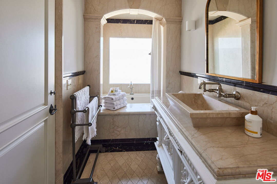 3817 Surfwood Road Malibu, CA 90265 - Photo 16 of 26 a bathroom with a granite countertop sink and a mirror