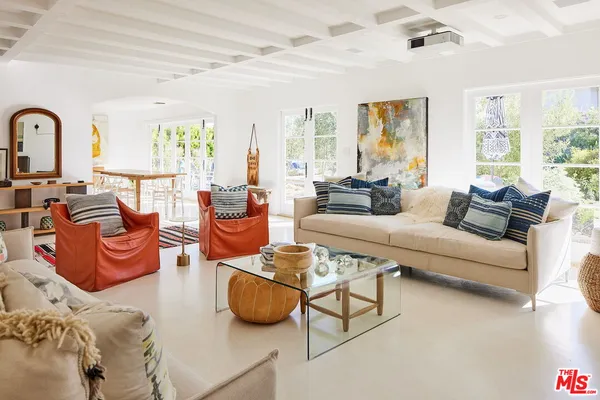 a living room with furniture a large window and a potted plant