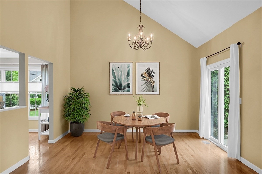 23 Southgate Road, Unit 23 Westford, MA 01886 - Photo 8 of 41 a dining room with wooden floor a chandelier a wooden table and chairs