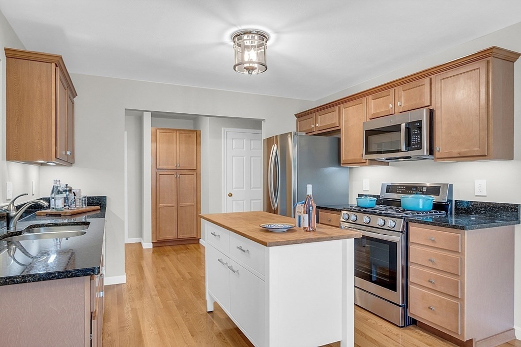 23 Southgate Road, Unit 23 Westford, MA 01886 - Photo 10 of 41 a kitchen with stainless steel appliances granite countertop a stove top oven a sink dishwasher and a microwave oven with wooden floor