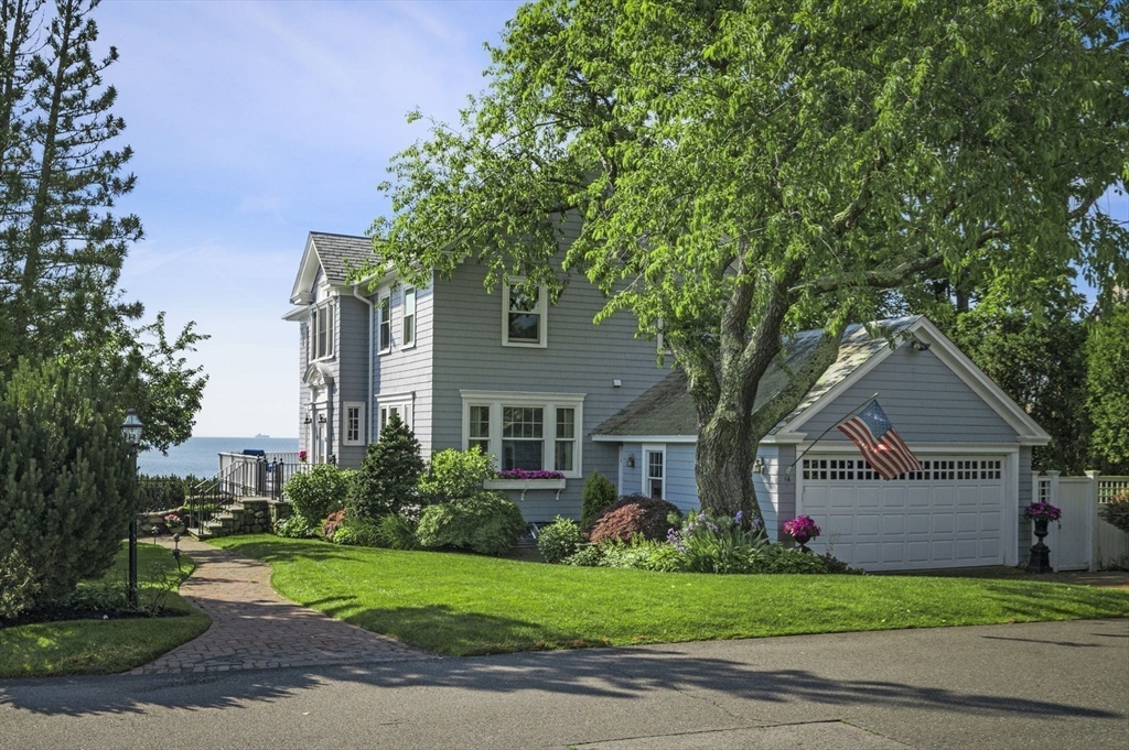 a front view of a house with a garden and trees