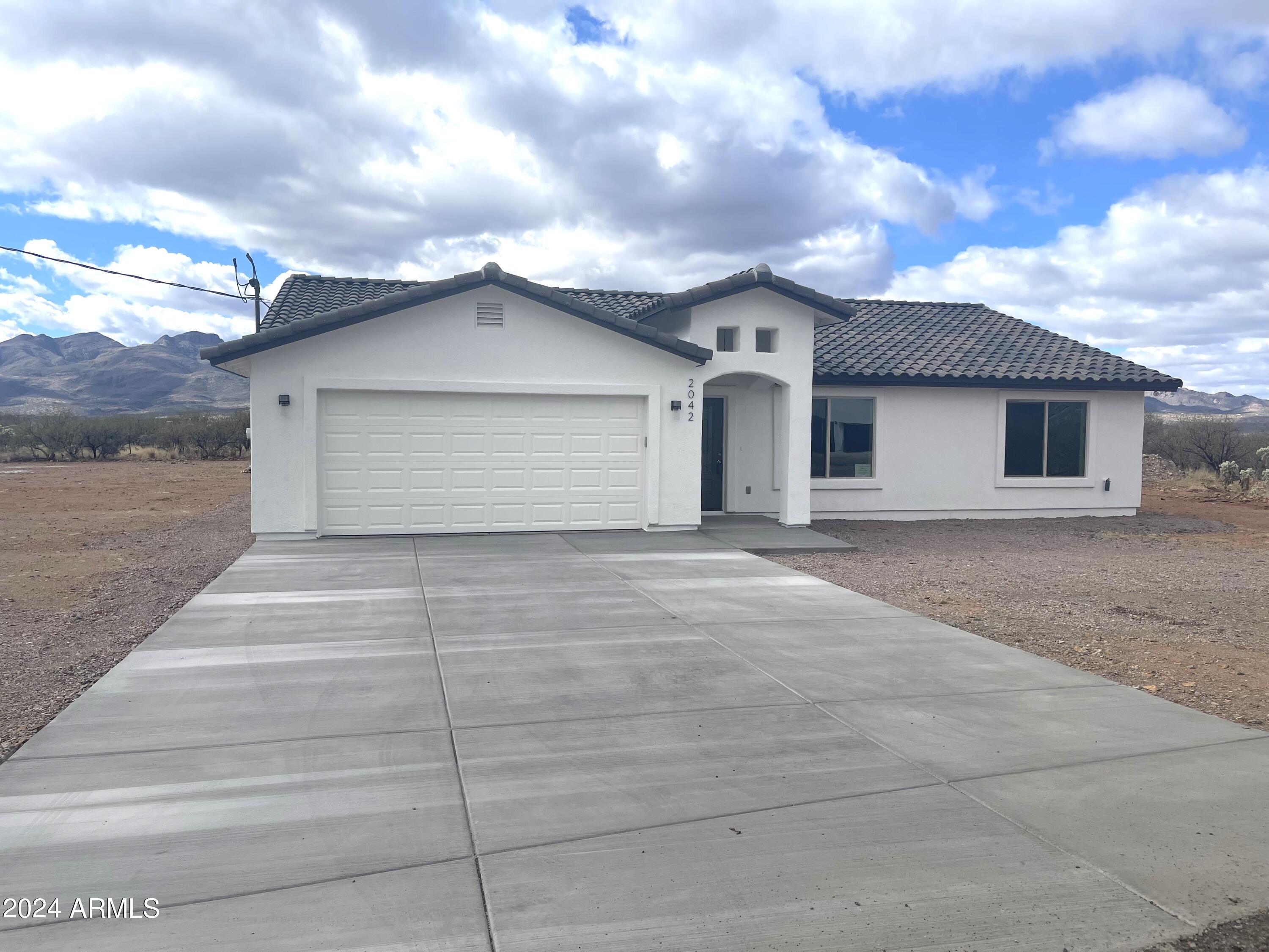 2042 Cobbs Court Rio Rico, AZ 85648 - Photo 2 of 39 a front view of a house with a garage