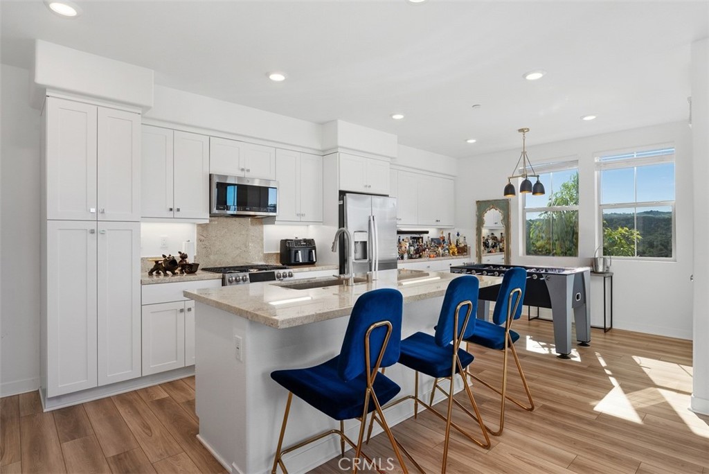 1100 Lasso Way, Unit 204 Rancho Mission Viejo, CA 92694 - Photo 2 of 41 a kitchen with kitchen island white cabinets and stainless steel appliances