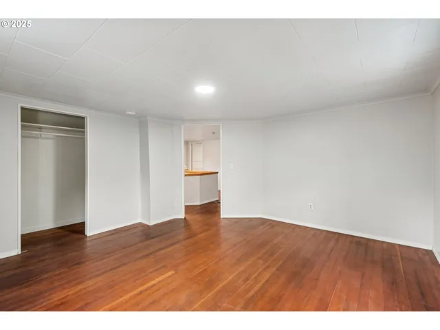 a view of an empty room with wooden floor