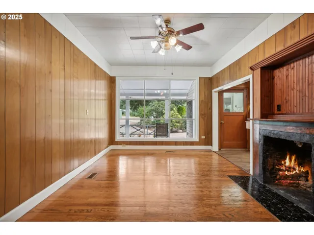 a view of an empty room with a fireplace and a window