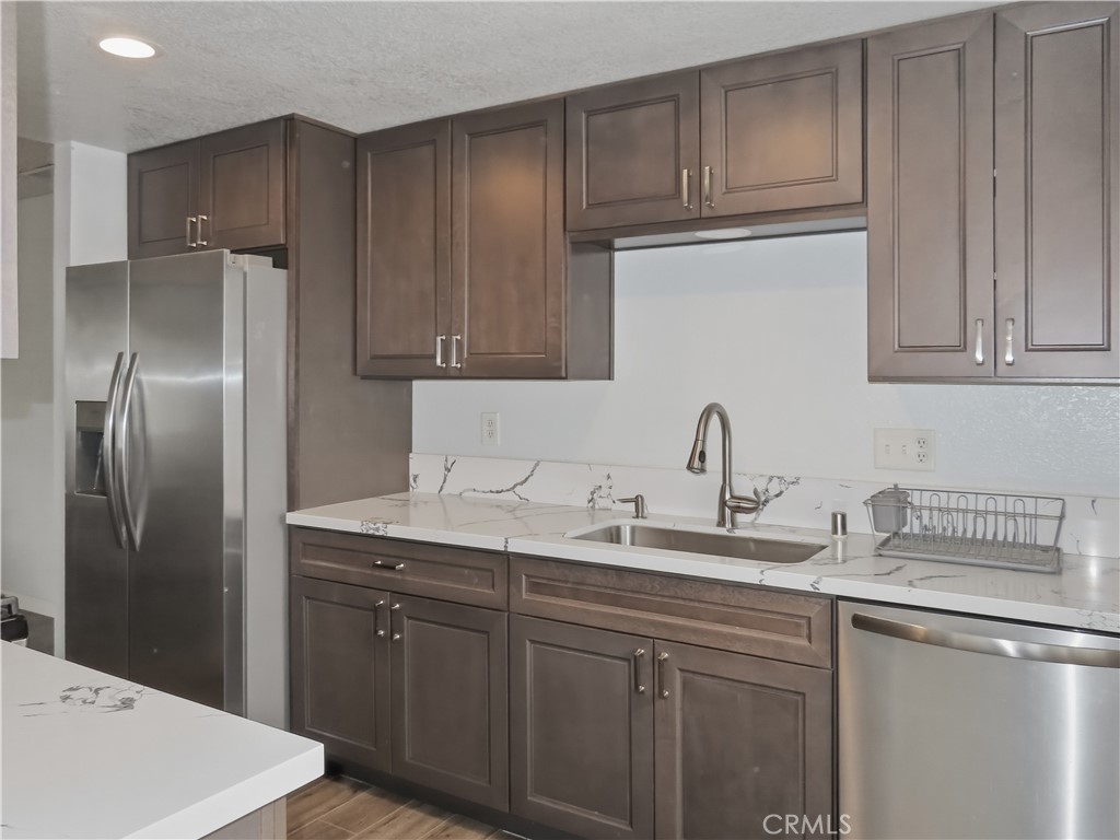 4409 Challen Avenue Riverside, CA 92503 - Photo 11 of 31 a kitchen with stainless steel appliances granite countertop a refrigerator sink and cabinets