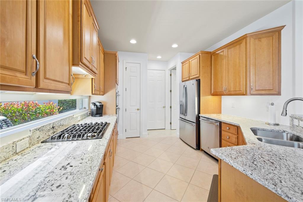 19924 Maddelena Circle Estero, FL 33967 - Photo 18 of 35 a kitchen with stainless steel appliances granite countertop a stove a sink and a refrigerator