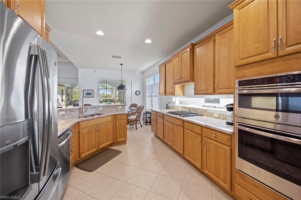 19924 Maddelena Circle Estero, FL 33967 - Photo 19 of 35 a large kitchen with stainless steel appliances granite countertop a refrigerator a stove and a sink