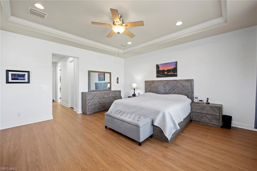 19924 Maddelena Circle Estero, FL 33967 - Photo 20 of 35 a bedroom with a bed and a chandelier