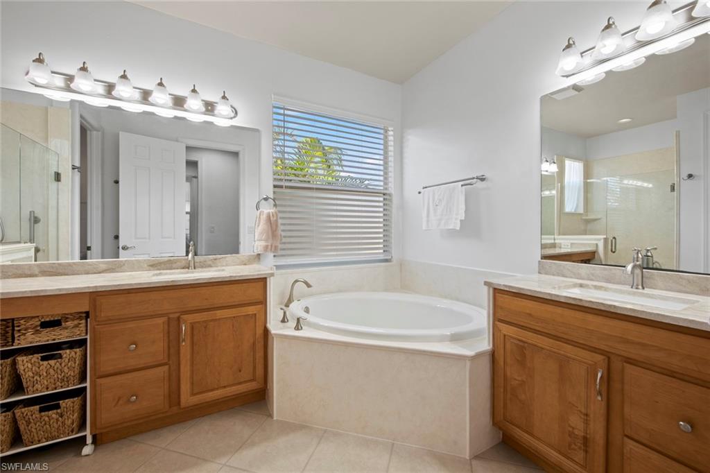 19924 Maddelena Circle Estero, FL 33967 - Photo 21 of 35 a bathroom with a tub sink and mirror