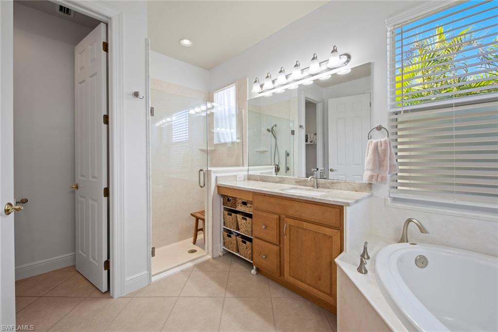 19924 Maddelena Circle Estero, FL 33967 - Photo 22 of 35 a bathroom with a tub sink and mirror