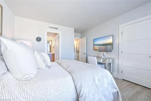 a bedroom with a bed a mirror and a lamp on table