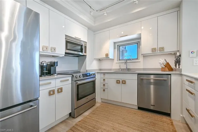 a kitchen with stainless steel appliances granite countertop a sink a stove a microwave and cabinets