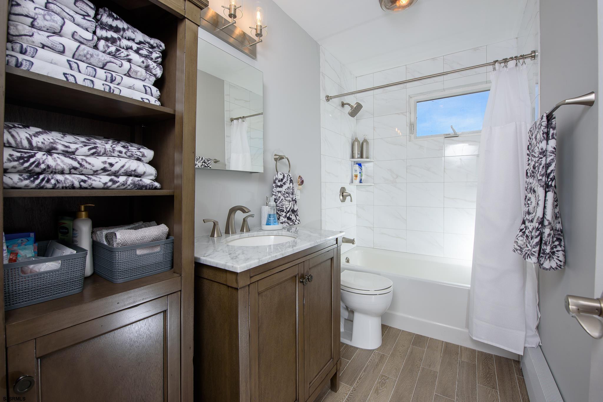 7 South Franklin Avenue, Unit 7 Margate City, NJ 08402 - Photo 11 of 16 a bathroom with a granite countertop toilet sink and mirror