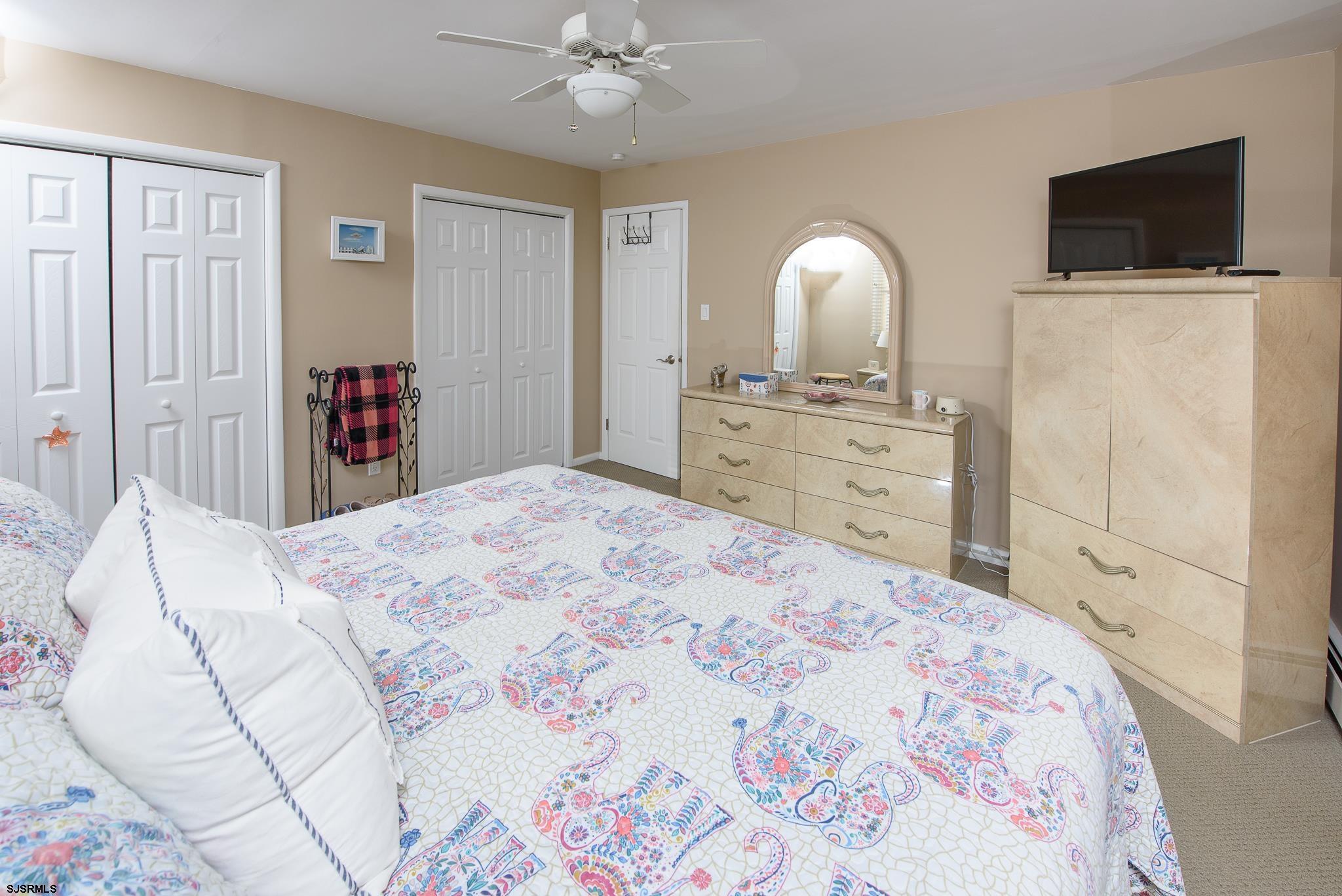 7 South Franklin Avenue, Unit 7 Margate City, NJ 08402 - Photo 12 of 16 a bedroom with a bed and a flat screen tv