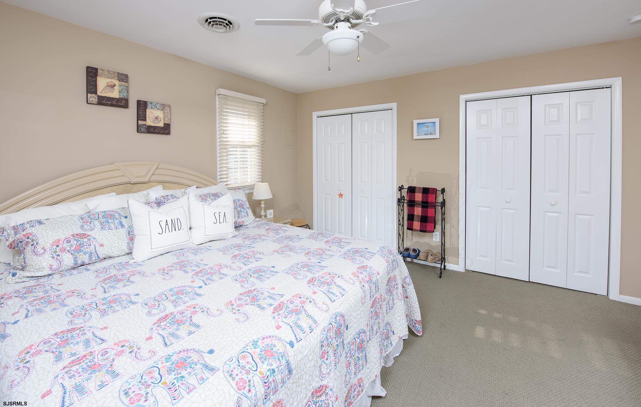 7 South Franklin Avenue, Unit 7 Margate City, NJ 08402 - Photo 13 of 16 a bedroom with a large bed and a chandelier
