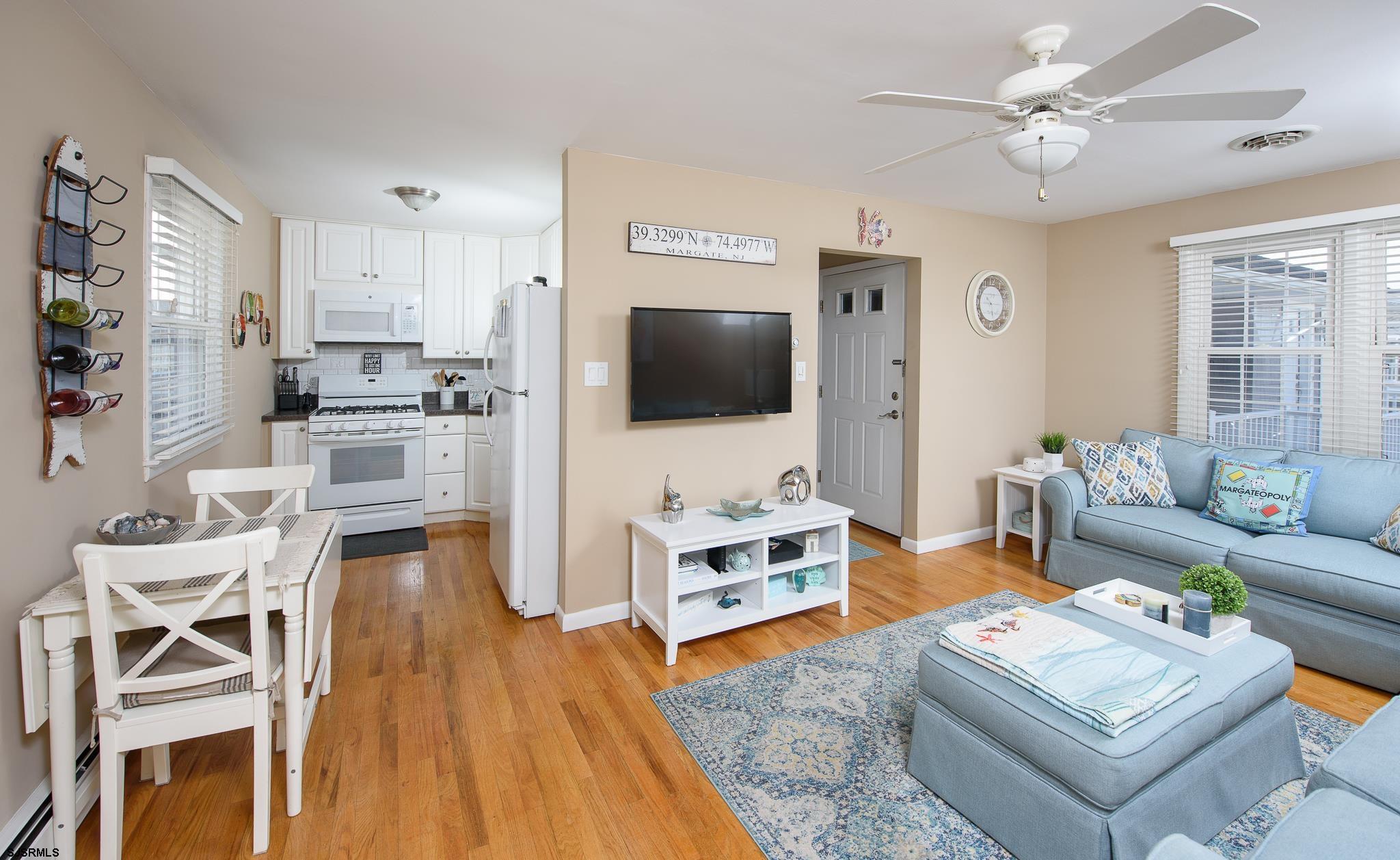 7 South Franklin Avenue, Unit 7 Margate City, NJ 08402 - Photo 8 of 16 a living room with furniture a dining table and a flat screen tv