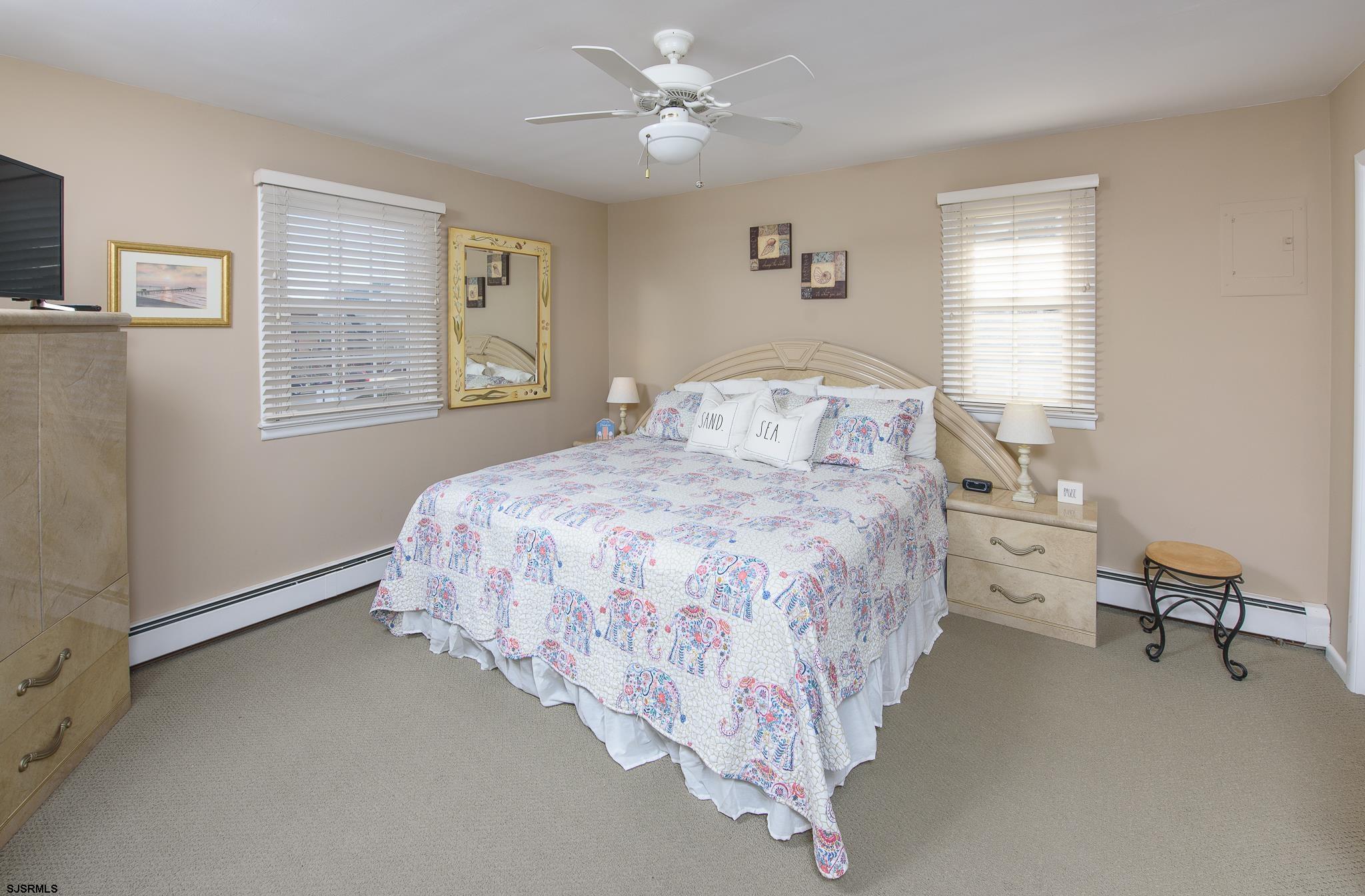 7 South Franklin Avenue, Unit 7 Margate City, NJ 08402 - Photo 10 of 16 a bedroom with a bed and a chandelier