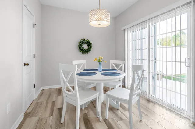 a dining room with chandelier and wooden floor