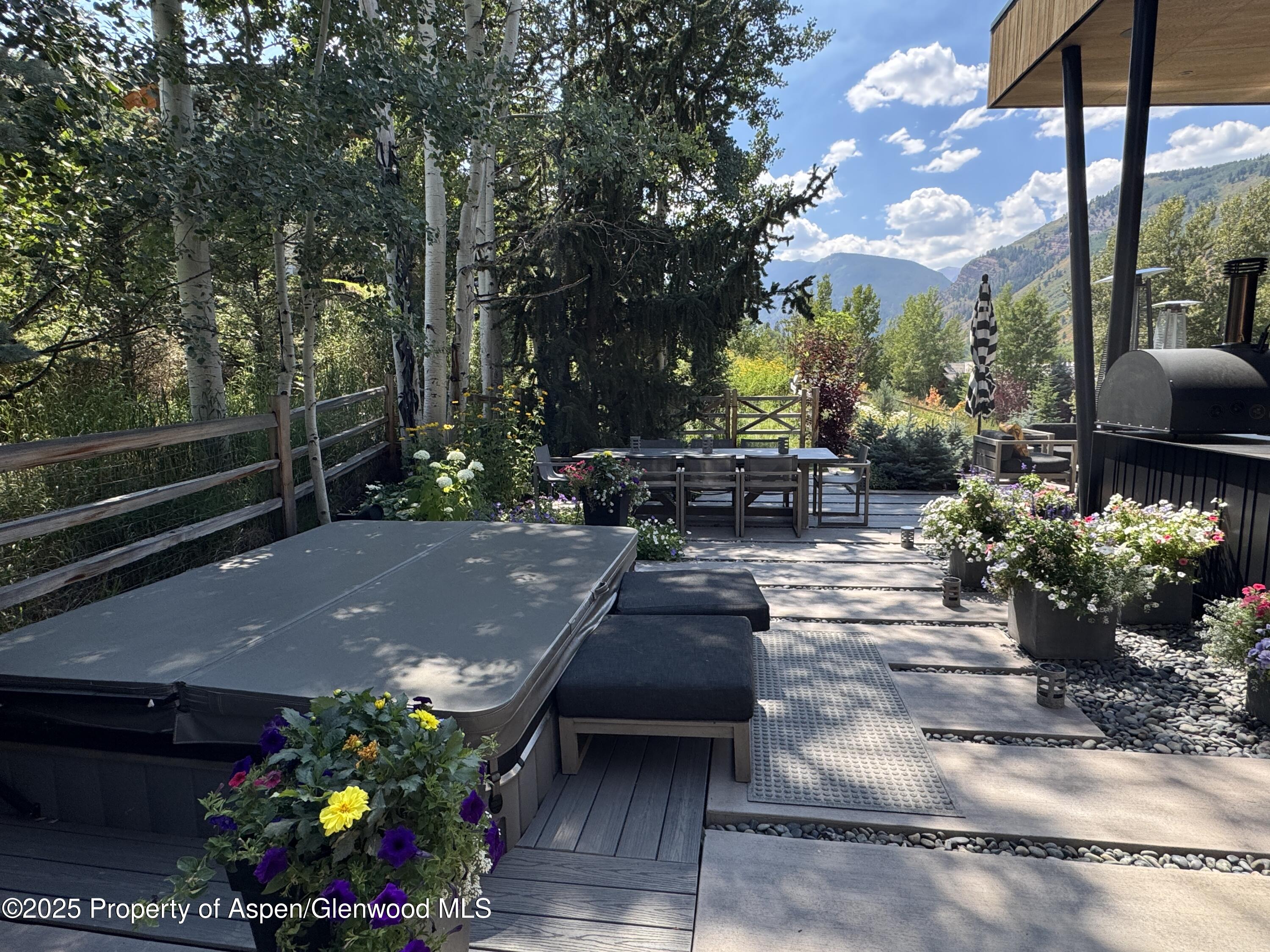 296 Glen Dee Road Aspen, CO 81611 - Photo 22 of 25 a view of a patio with table and chairs potted plants and large tree