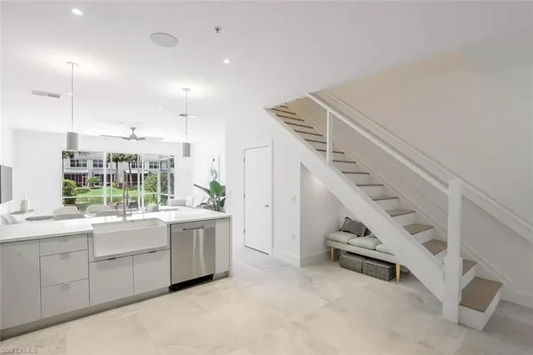 a kitchen with white cabinets and sink