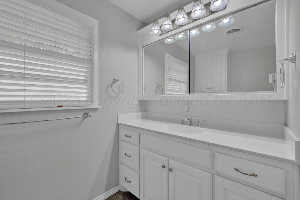 4231 Camp Lane Amarillo, TX 79110 - Photo 20 of 36 a bathroom with a sink and a mirror