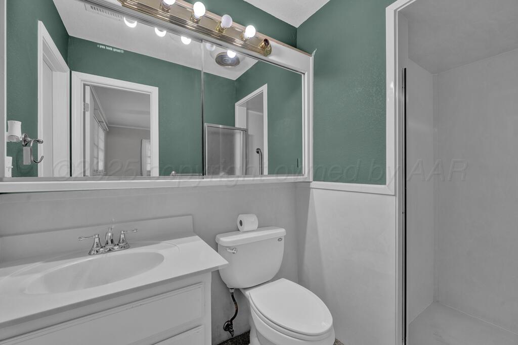 4231 Camp Lane Amarillo, TX 79110 - Photo 29 of 36 a bathroom with a toilet a sink and mirror