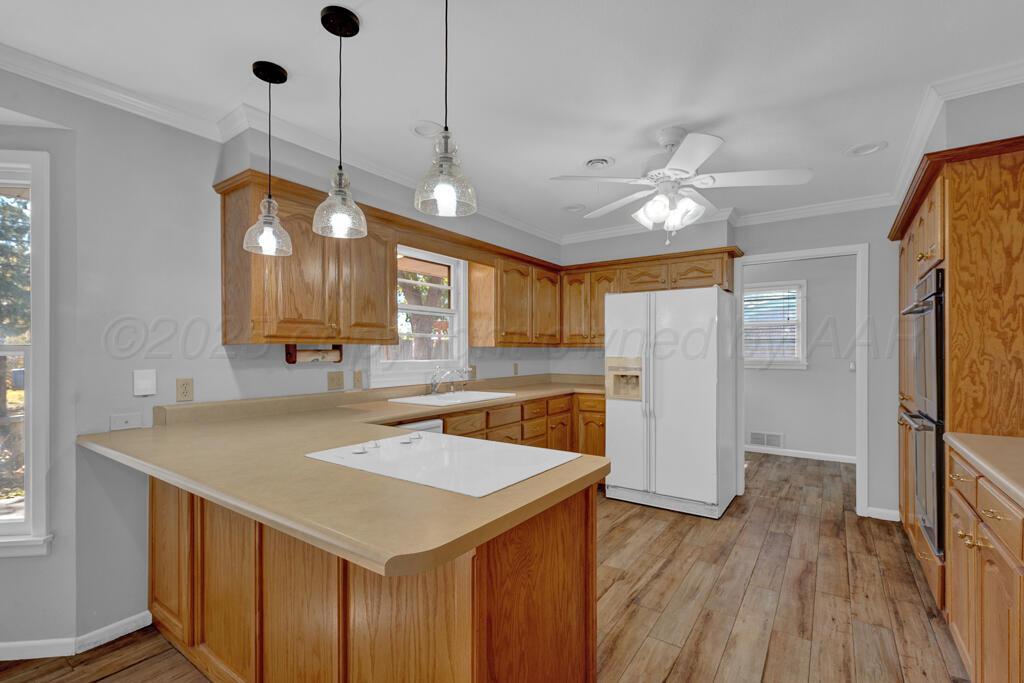 4231 Camp Lane Amarillo, TX 79110 - Photo 9 of 36 a kitchen with a refrigerator a sink and a wooden floor