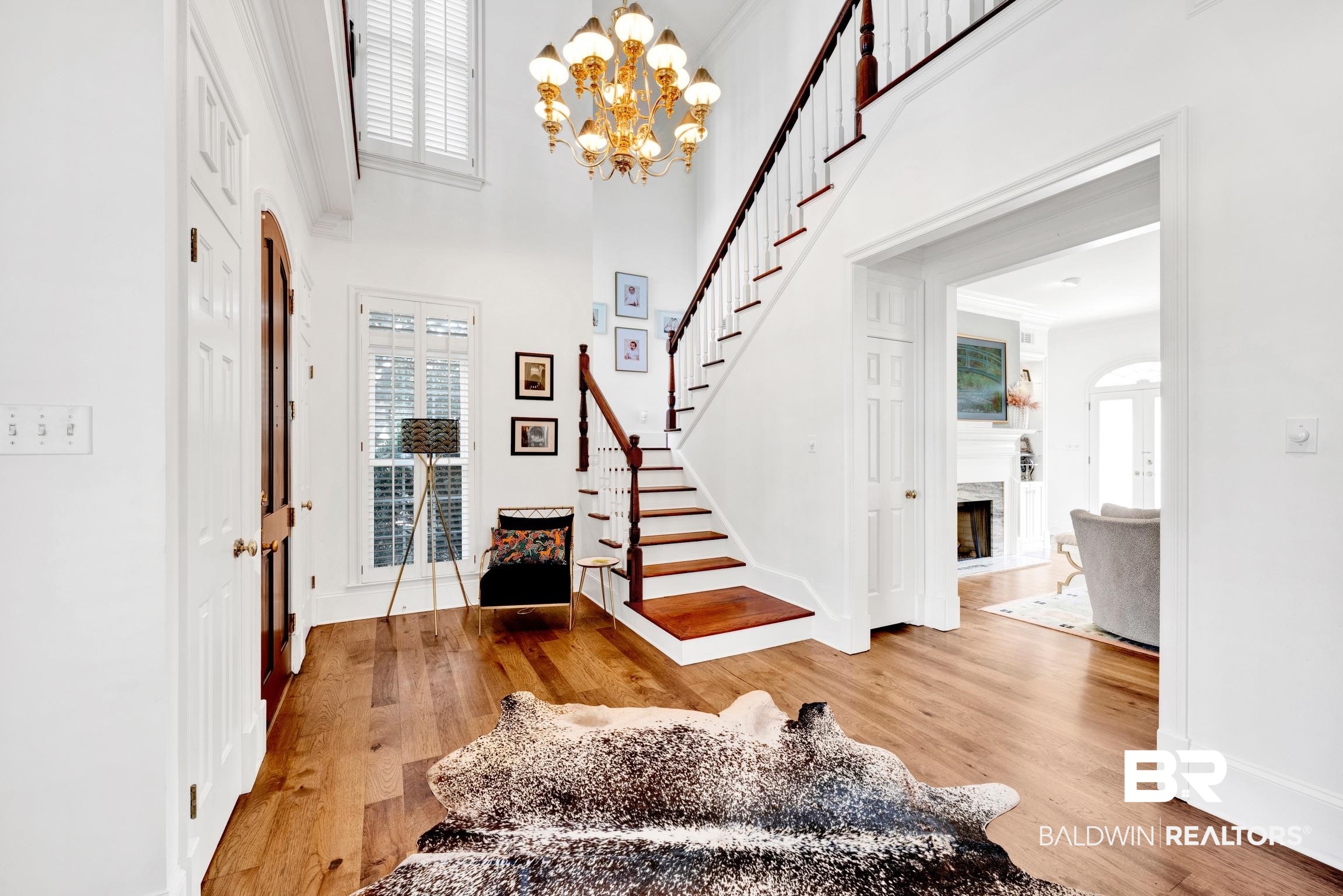4 Savannah Court Mobile, AL 36608 - Photo 3 of 32 Foyer entrance featuring ornamental molding, light wood-type flooring, a high ceiling, a premium fireplace, and suspended lighting