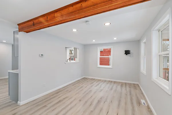 a view of a big room with wooden floor and windows