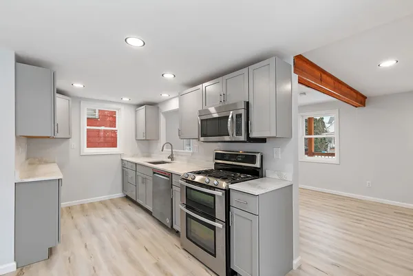a kitchen with stainless steel appliances a stove sink microwave and cabinets