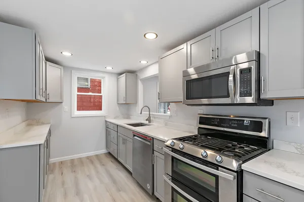 a kitchen with stainless steel appliances granite countertop a stove microwave and sink