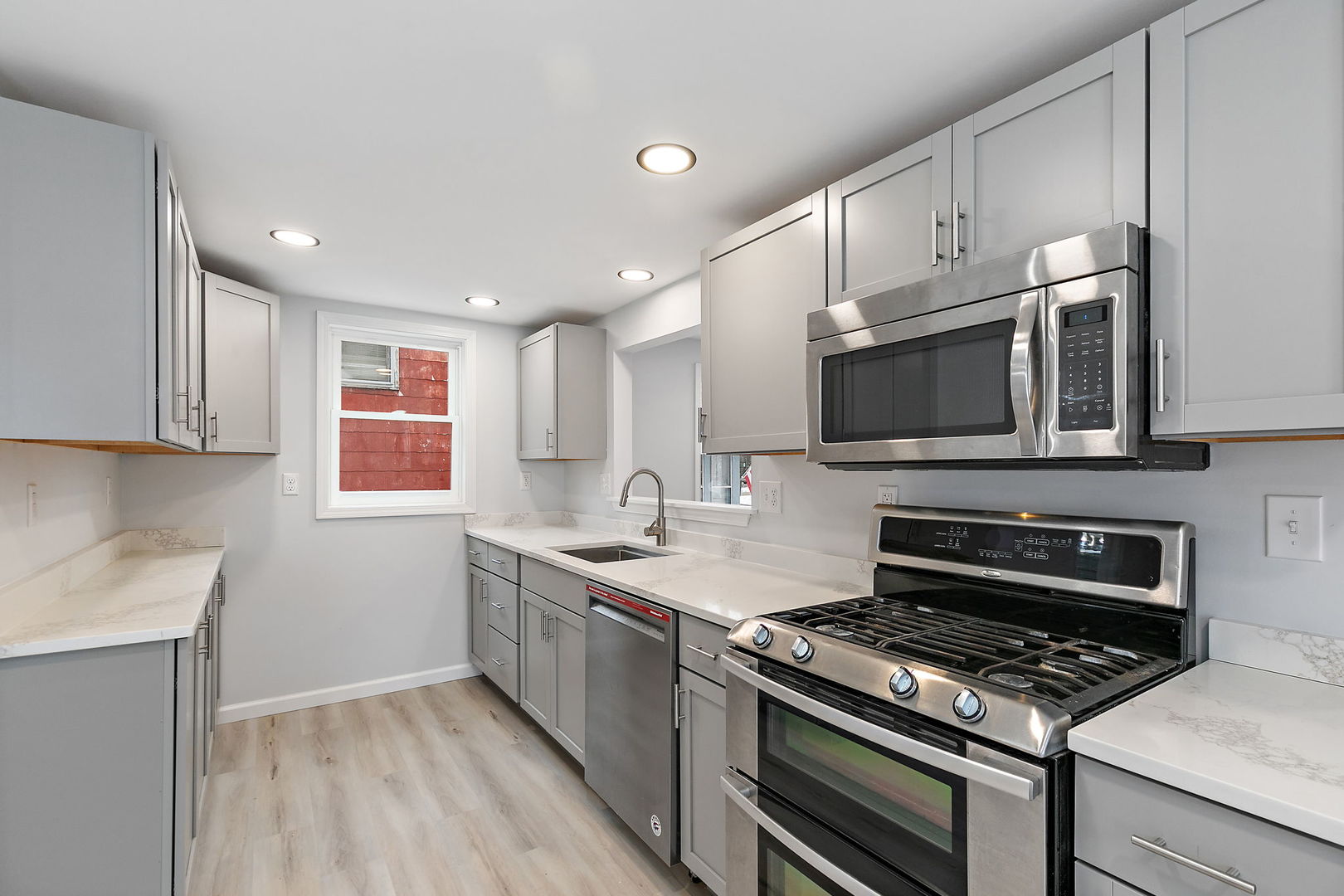613 South 1st Street DeKalb, IL 60115 - Photo 7 of 21 a kitchen with stainless steel appliances granite countertop a stove microwave and sink